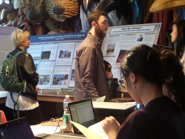 Residents and visitors stop in to read about student research on the market.